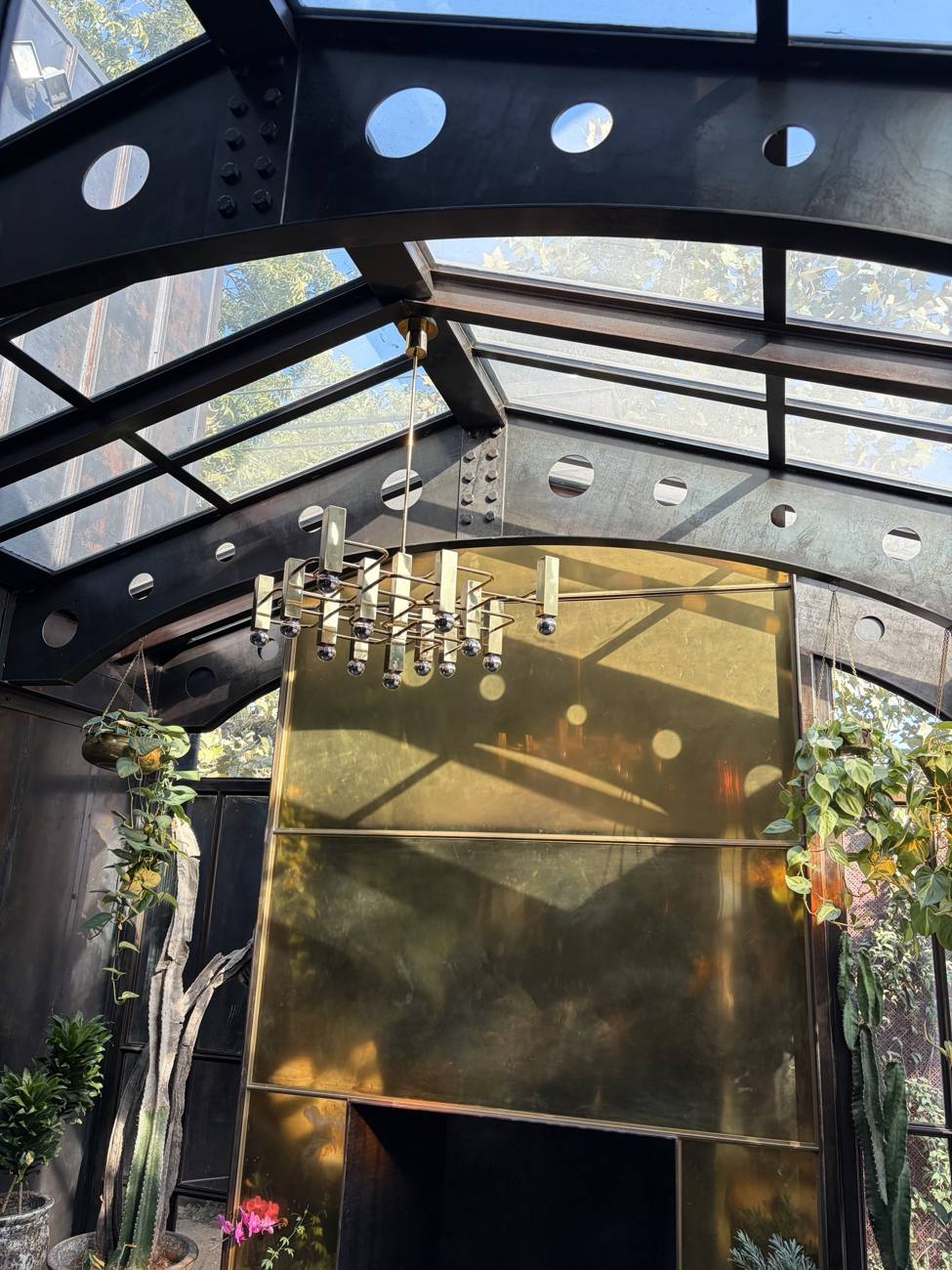 Steel and glass roof conservatory with a brass fireplace wall
