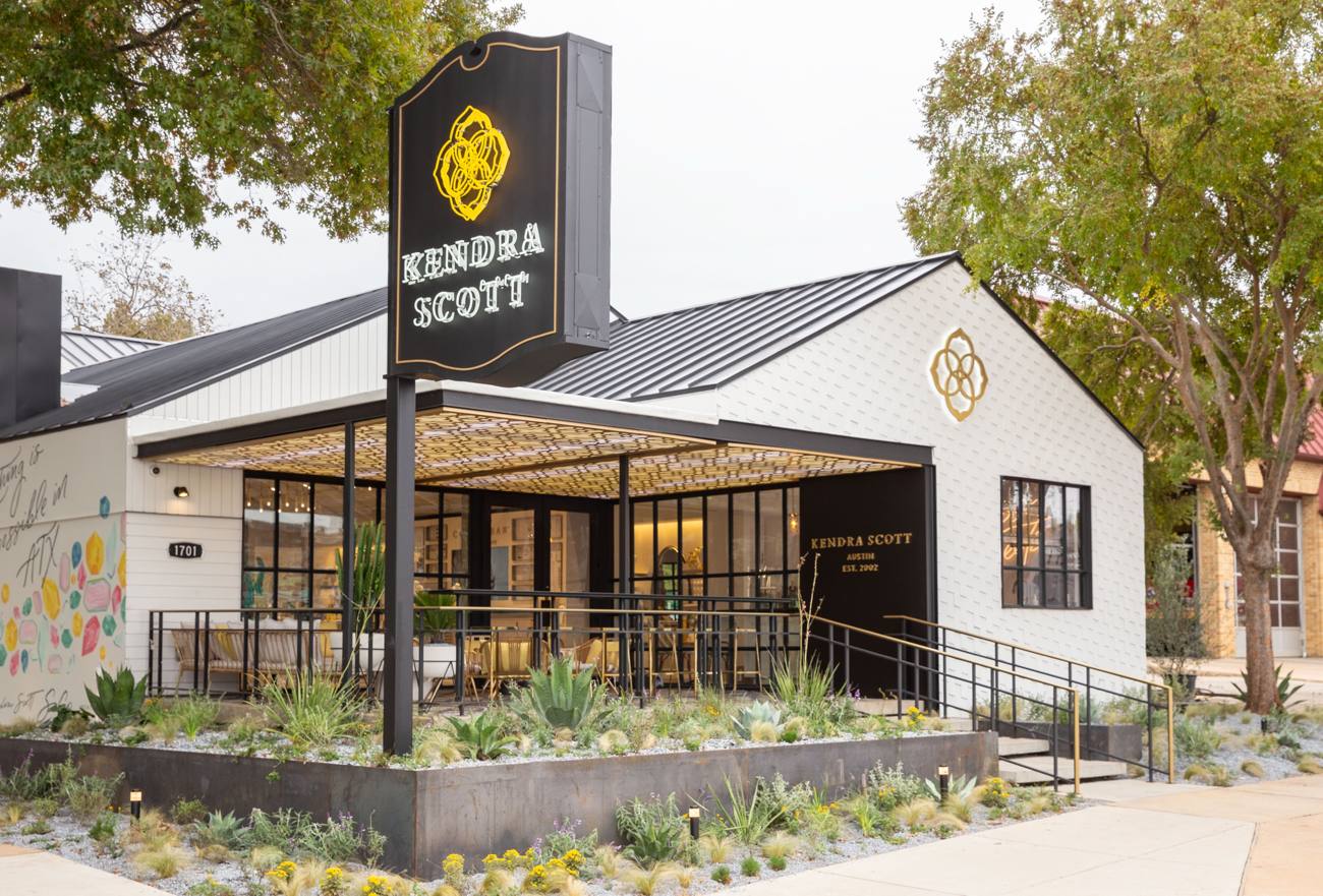 Retail flagship with black steel storefront windows under a patterned canopy