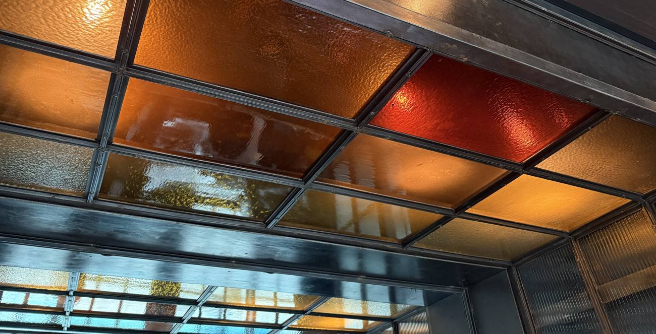 Steel grid ceiling glazed with amber, red and hammered stained glass
